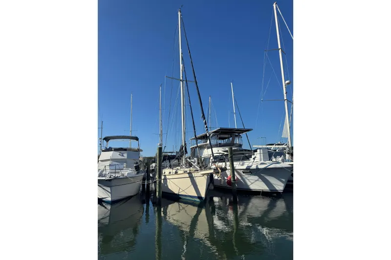 Slide: The Image of Sailboats docked at marina, featuring a 1991 Island Packet Yachts 38 under clear blue sky. - 3