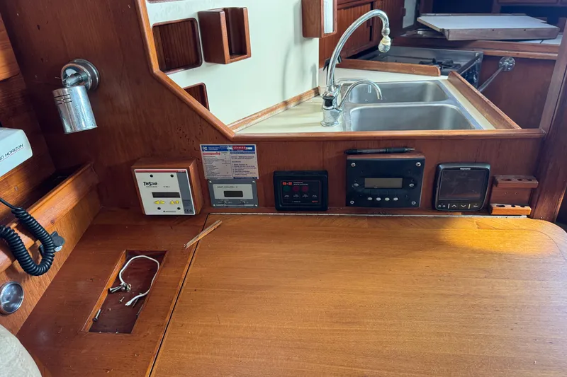 Slide: The Image of Interior of a 1991 Island Packet Yachts 38, featuring a wooden navigation station and sink. - 33