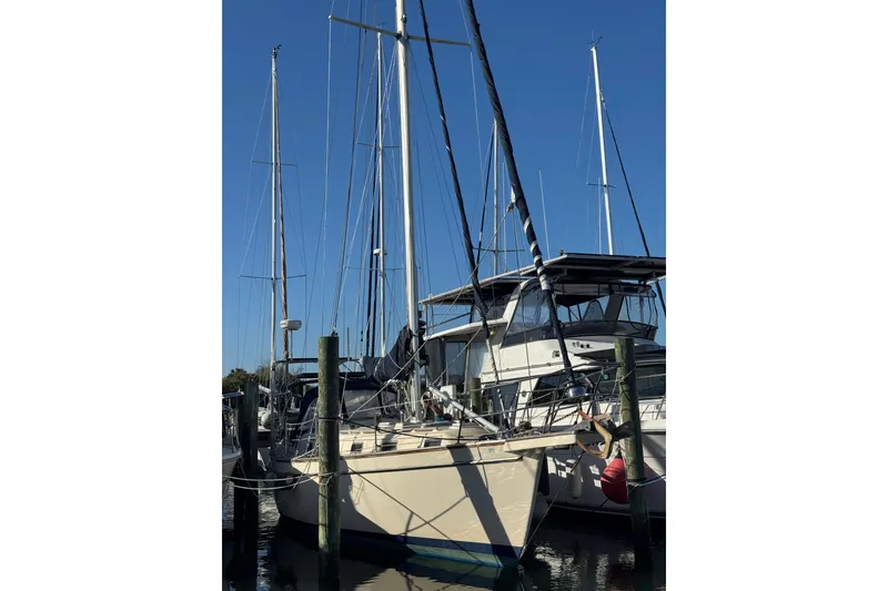 Slide: The Image of 1991 Island Packet Yachts 38 sailboat docked at marina under clear blue sky. - 4