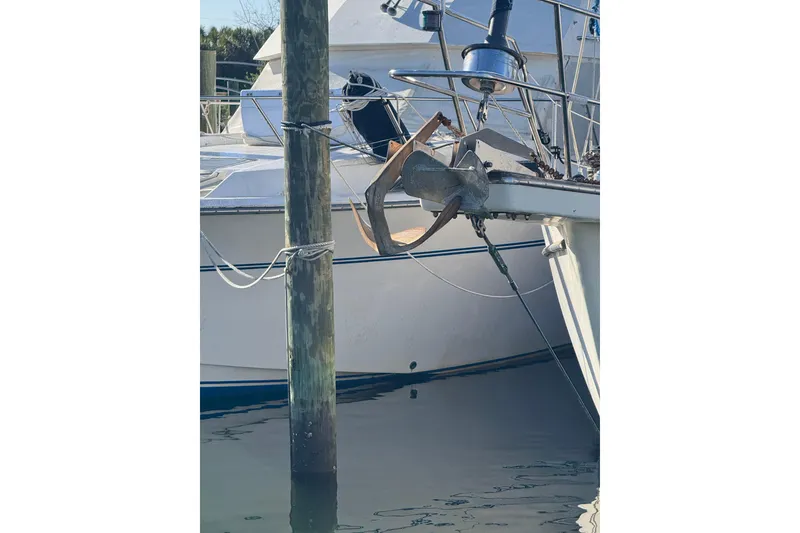 Slide: The Image of 1991 Island Packet Yachts 38 anchored at a marina, showcasing its sturdy bow design. - 7