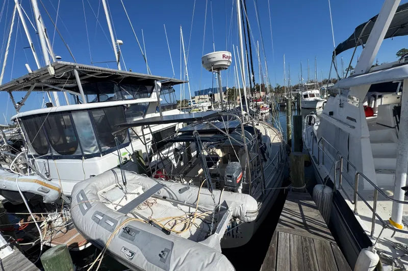 Slide: The Image of Docked 1991 Island Packet Yachts 38 sailboat with inflatable dinghy, surrounded by other boats. - 8