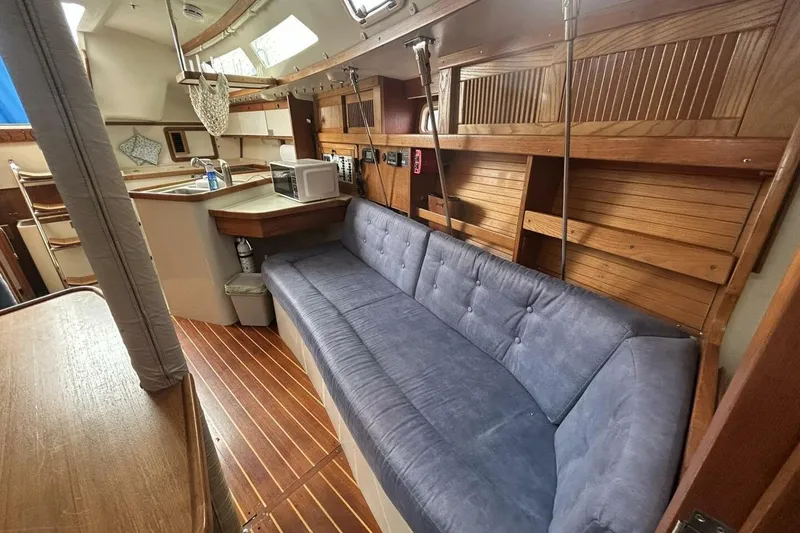 Slide: The Image of 1995 Catalina 320 yacht interior with blue sofa and wooden accents. - 24