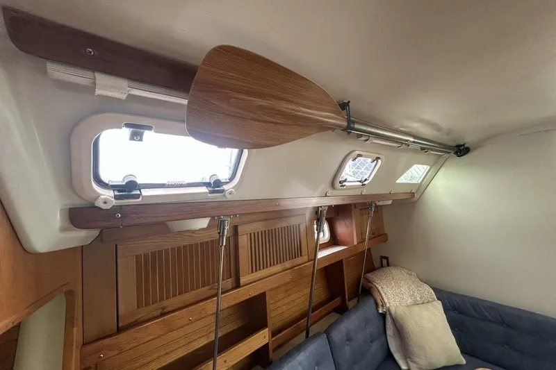 Slide: The Image of Interior of a 1995 Catalina 320 sailboat with wooden paddle and cozy seating. - 25