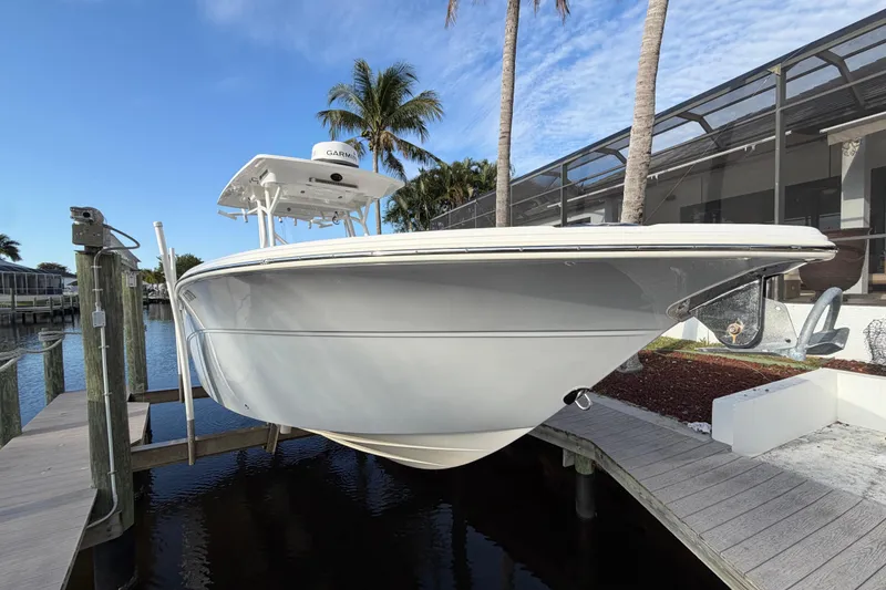 Slide: The Image of 2022 Sea Fox 288 Commander boat docked near palm trees and waterfront home. - 34
