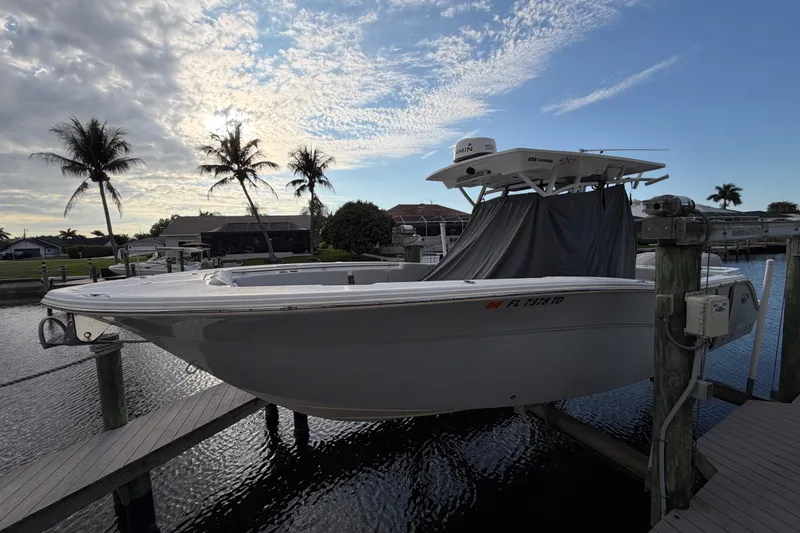 Slide: The Image of 2022 Sea Fox 288 Commander boat docked with palm trees and cloudy sky backdrop. - 37