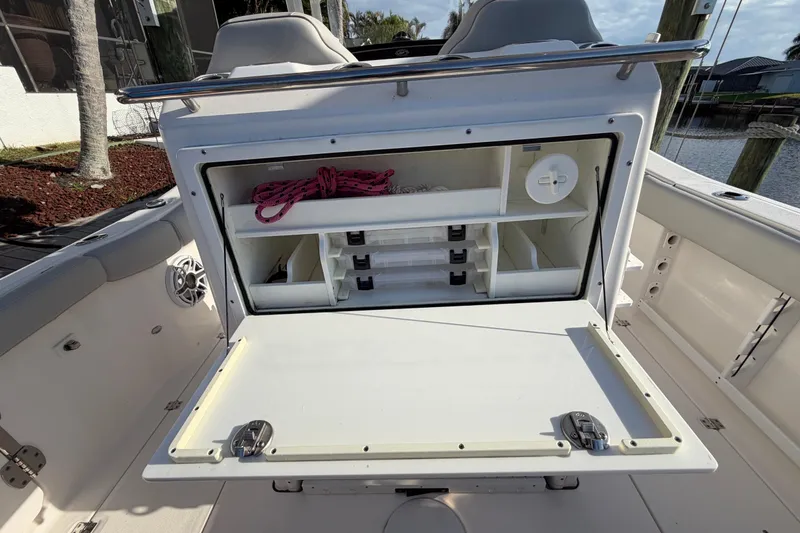 Slide: The Image of 2022 Sea Fox 288 Commander boat storage compartment with organized shelves and rope. - 55