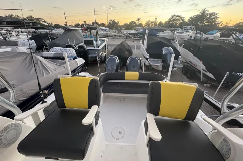 Slide: The Image of 2006 Century 2400 Walk-Around boat interior with yellow and black seating at marina. - 16