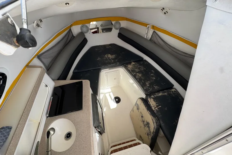 Slide: The Image of Interior of 2006 Century 2400 Walk-Around boat with seating and compact amenities. - 17