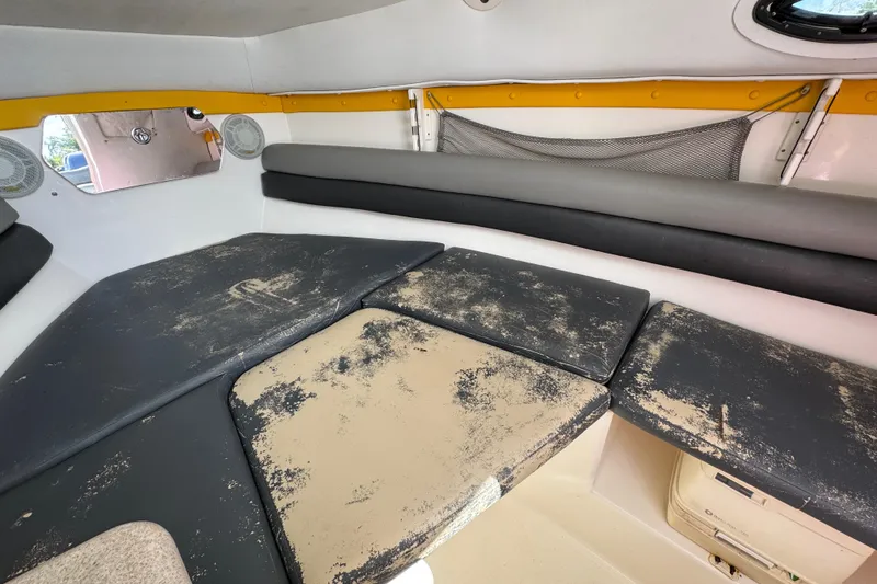 Slide: The Image of Interior cabin of a 2006 Century 2400 Walk-Around boat with worn cushions. - 18