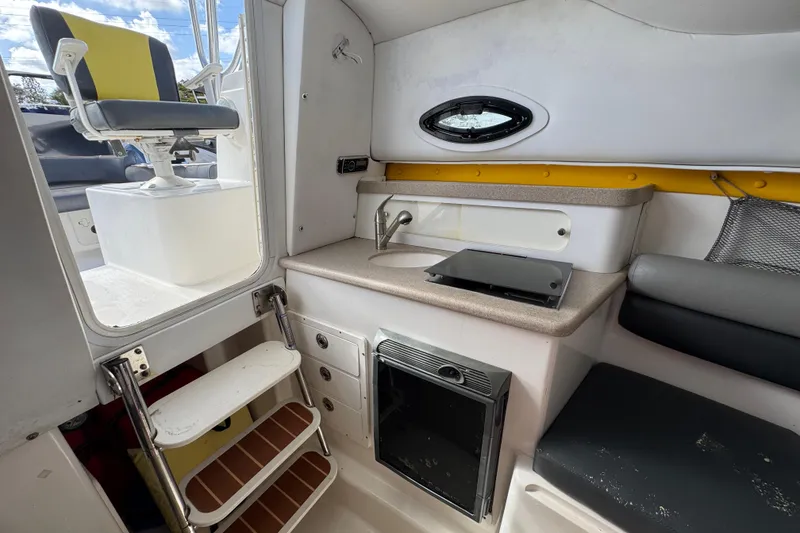Slide: The Image of Interior of a 2006 Century 2400 Walk-Around boat with kitchenette and seating area. - 23