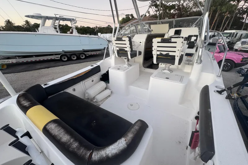Slide: The Image of 2006 Century 2400 Walk-Around boat interior with seating and helm, parked outdoors. - 3