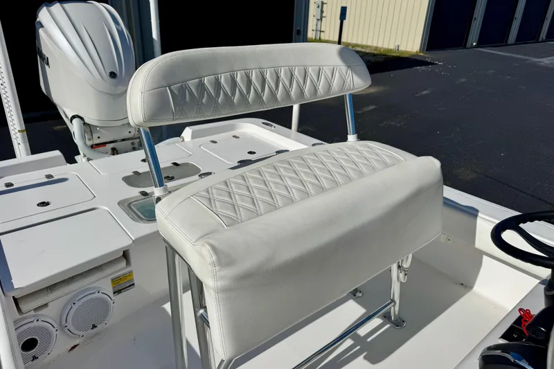 Slide: The Image of 2023 Contender 26 Bay boat interior with white cushioned seating and Yamaha engine. - 14