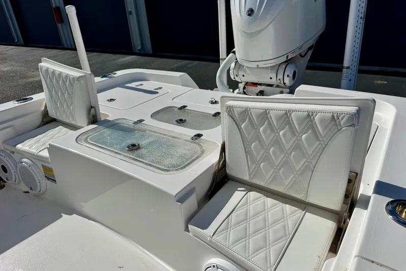 Slide: The Image of 2023 Contender 26 Bay boat interior with white cushioned seating and storage compartments. - 16