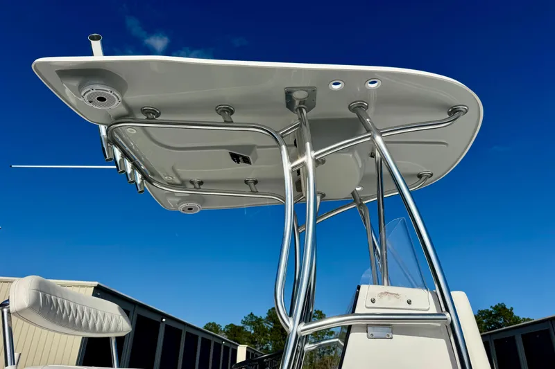 Slide: The Image of 2023 Contender 26 Bay boat with T-top and rod holders against blue sky. - 19