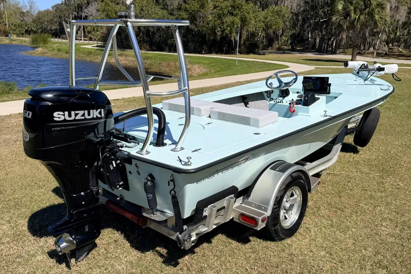 The Image of 2023 East Cape 18 EVO X boat with Suzuki engine on a trailer by a lake. - 0