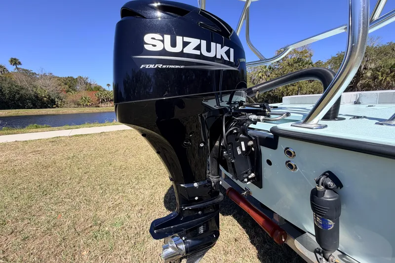 Slide: The Image of 2023 East Cape 18 EVO X boat with Suzuki four-stroke outboard motor by a lake. - 19