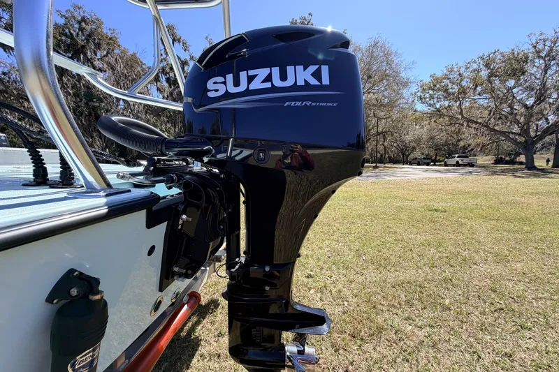 Slide: The Image of 2023 East Cape 18 EVO X boat with Suzuki four-stroke outboard motor in a grassy area. - 20