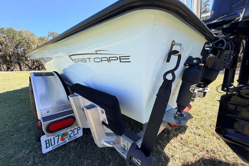 Slide: The Image of 2023 East Cape 18 EVO X boat on trailer, rear view with license plate visible. - 25