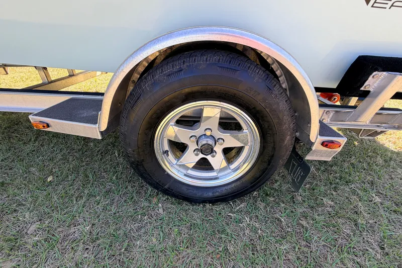 Slide: The Image of 2023 East Cape 18 EVO X trailer wheel on grass, showcasing tire and rim details. - 26