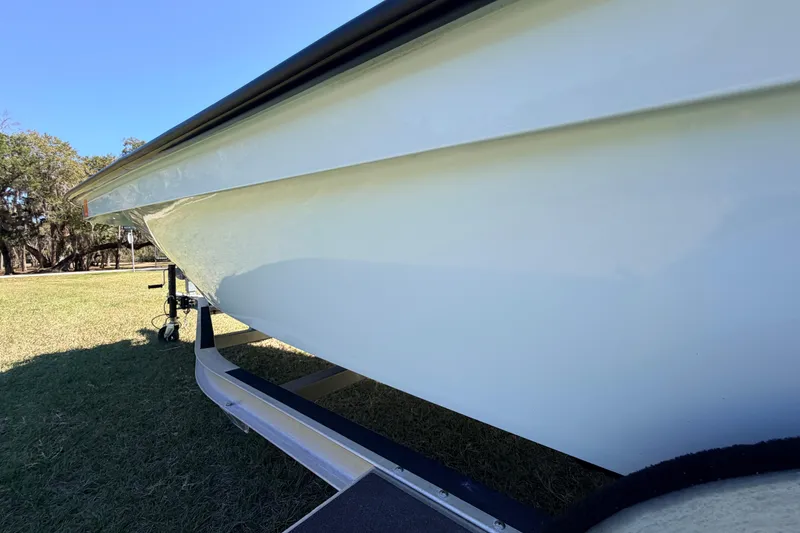 Slide: The Image of 2023 East Cape 18 EVO X boat on trailer, side view in grassy area. - 27