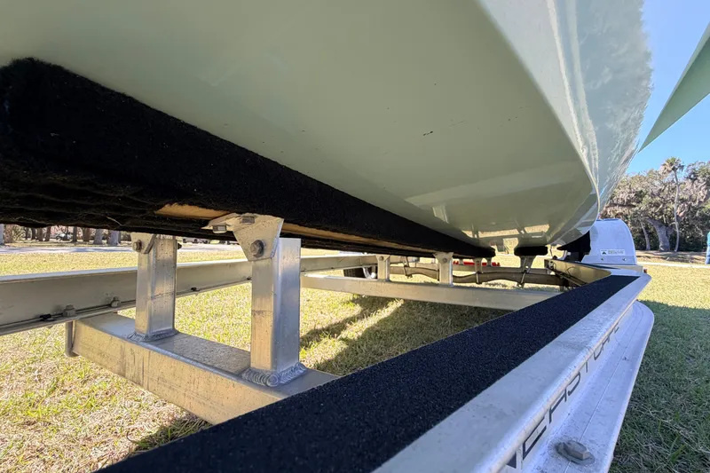 Slide: The Image of 2023 East Cape 18 EVO X boat on trailer, underside view, grassy background. - 29
