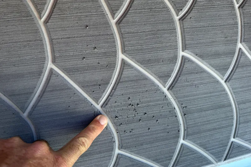 Slide: The Image of Textured surface with geometric pattern, finger pointing at imperfections, East Cape 18 EVO X, 2023. - 43