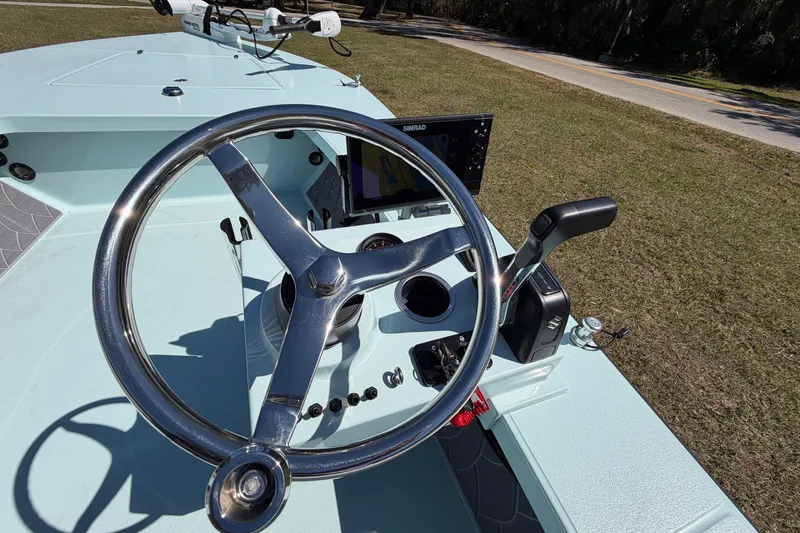 Slide: The Image of 2023 East Cape 18 EVO X boat steering console with controls and navigation display. - 48