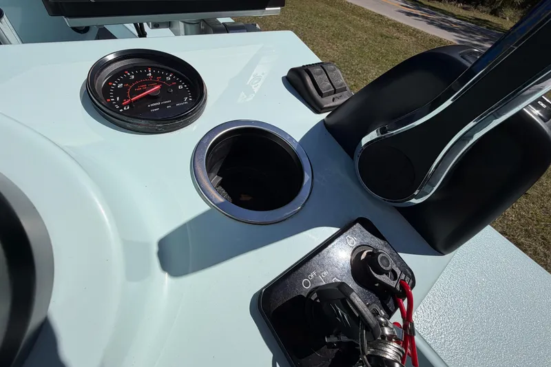 Slide: The Image of 2023 East Cape 18 EVO X boat dashboard with gauge, cup holder, and controls. - 50