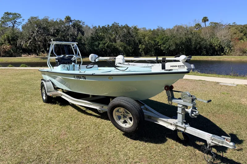 Slide: The Image of 2023 East Cape 18 EVO X boat on trailer by a scenic riverbank. - 6