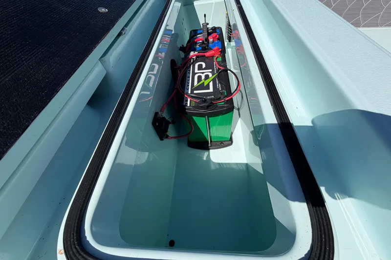 Slide: The Image of Battery compartment of 2023 East Cape 18 EVO X boat, featuring a green battery. - 61