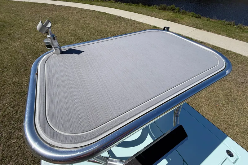 Slide: The Image of 2023 East Cape 18 EVO X boat platform with rod holder, grassy background. - 81