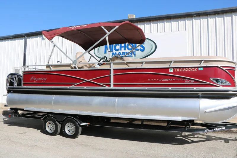The Image of 2014 Regency Party Barge 254 XP3 pontoon boat with red canopy and trailer. - 1