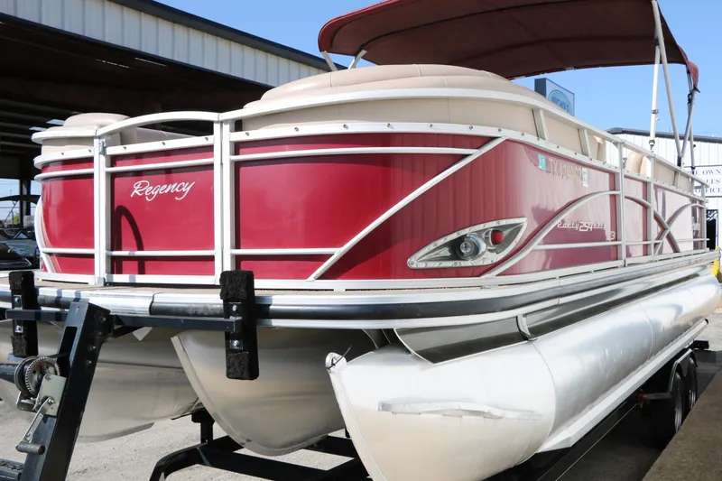 Slide: The Image of 2014 Regency Party Barge 254 XP3 pontoon boat with red exterior on trailer. - 10