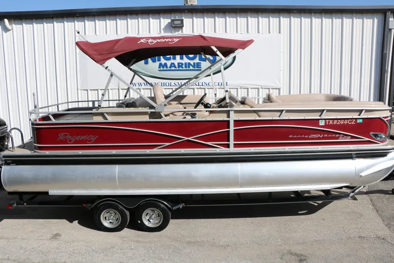 Slide: The Image of 2014 Regency Party Barge 254 XP3 pontoon boat with red canopy and trailer. - 19