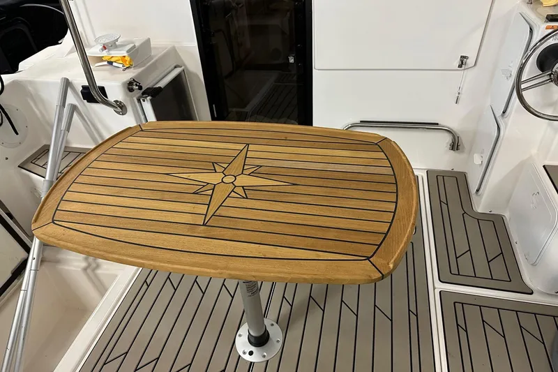 Slide: The Image of 2023 Cutwater C-32 Coupe interior with wooden table and nautical design. - 19