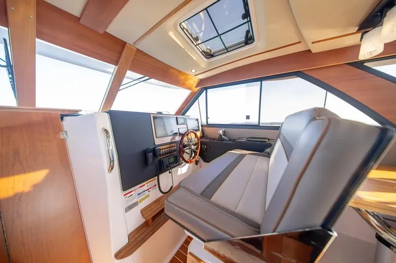 Slide: The Image of 2023 Cutwater C-32 Coupe interior with modern helm, luxurious seating, and panoramic windows. - 28