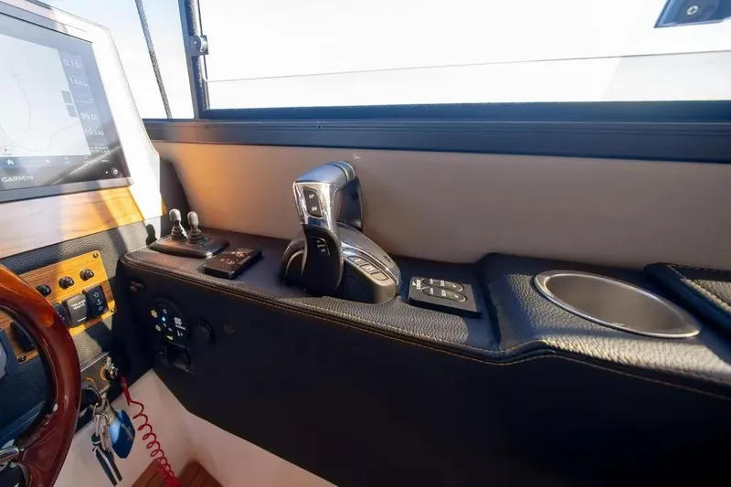 Slide: The Image of 2023 Cutwater C-32 Coupe helm with controls, navigation screen, and cup holder. - 29