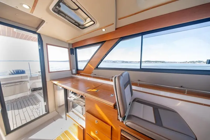 Slide: The Image of Interior of 2023 Cutwater C-32 Coupe boat with modern seating and large windows. - 32