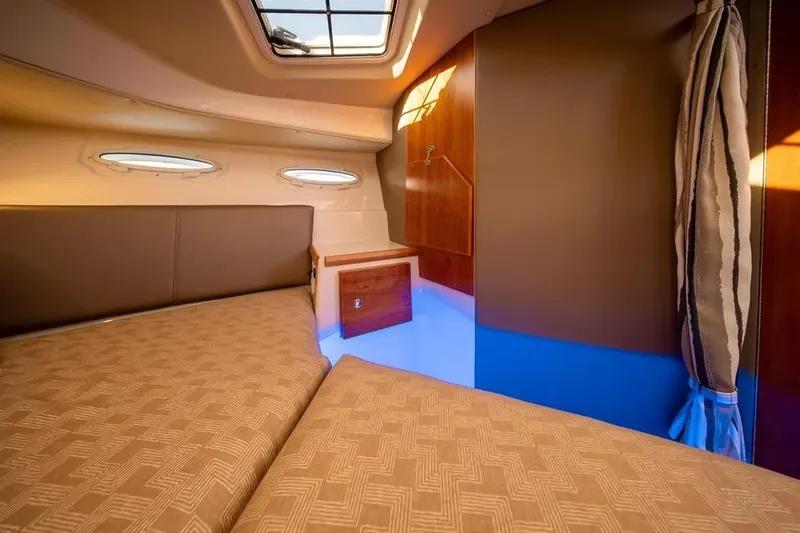 Slide: The Image of 2023 Cutwater C-32 Coupe cabin interior with cozy bedding and natural light. - 35