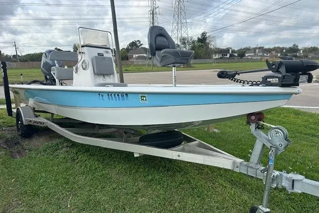 The Image of Avid 21 Mag 2021 boat on trailer, blue and white design, parked on grass. - 0