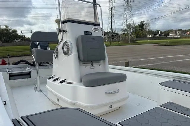 Slide: The Image of 2021 Avid 21 Mag boat interior with seating and console, parked outdoors. - 10