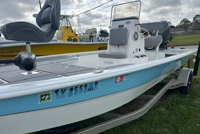Slide: The Image of Avid 21 Mag 2021 boat with blue trim on a trailer, parked outdoors. - 12