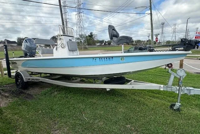 Slide: The Image of 2021 Avid 21 Mag boat on trailer, parked on grass, under cloudy sky. - 14
