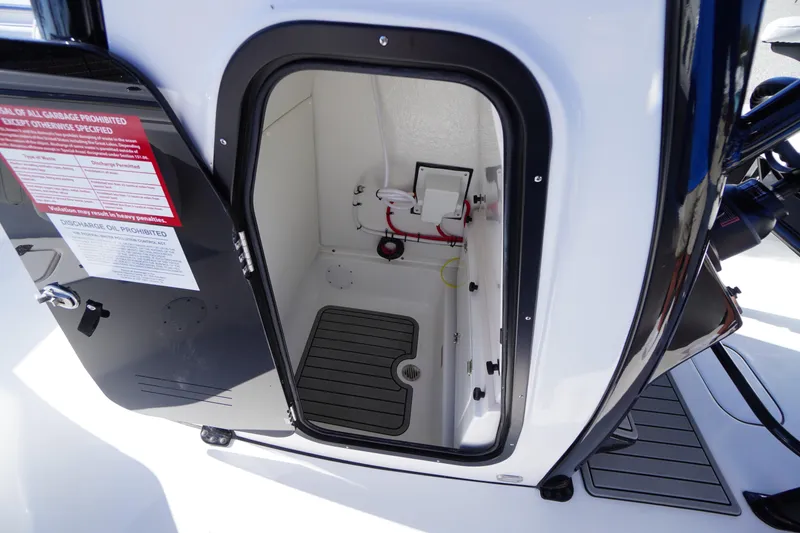 Slide: The Image of 2026 Tidewater 232 CC Adventure boat storage compartment with open door and safety instructions. - 21