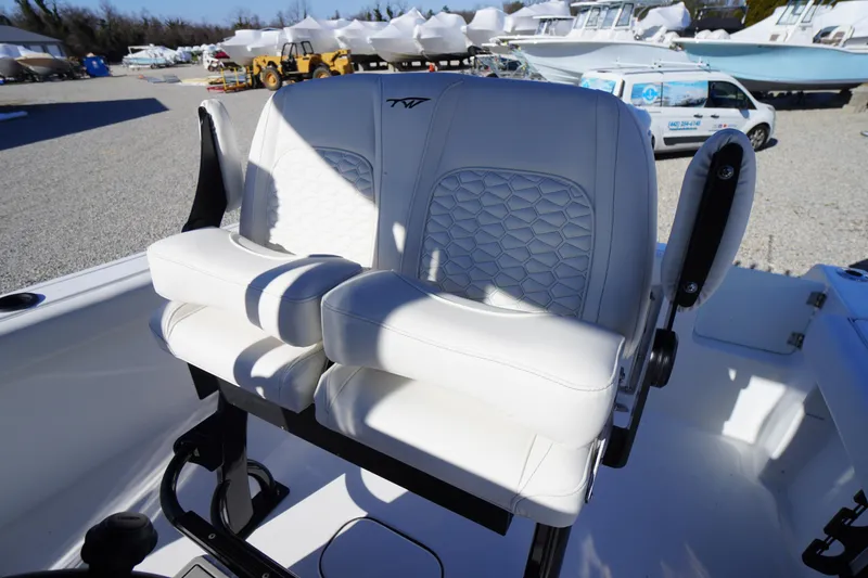 Slide: The Image of 2026 Tidewater 232 CC Adventure boat with white cushioned seating in a marina setting. - 38