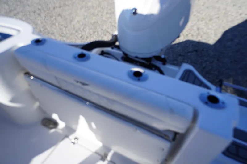 Slide: The Image of 2026 Tidewater 232 CC Adventure boat interior with rod holders and engine view. - 45