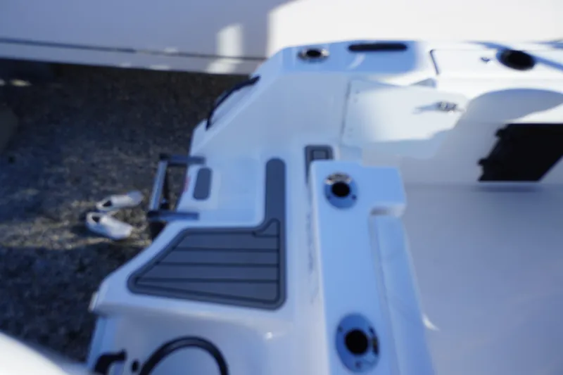Slide: The Image of 2026 Tidewater 232 CC Adventure boat deck with rod holders and swim ladder. - 65