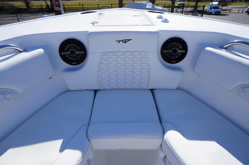 Slide: The Image of 2026 Tidewater 232 CC Adventure boat interior with white cushioned seating and speakers. - 9