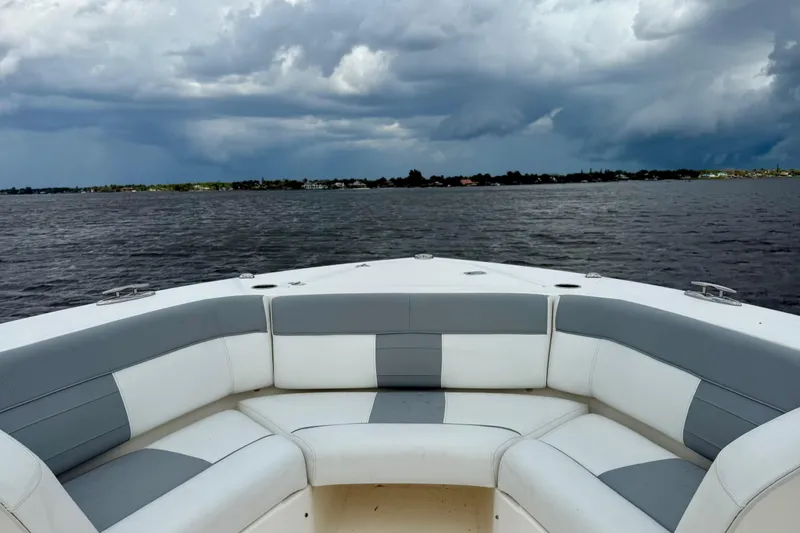 Slide: The Image of Bow seating on 2020 Pursuit S 408 Sport boat with stormy sky over water. - 13