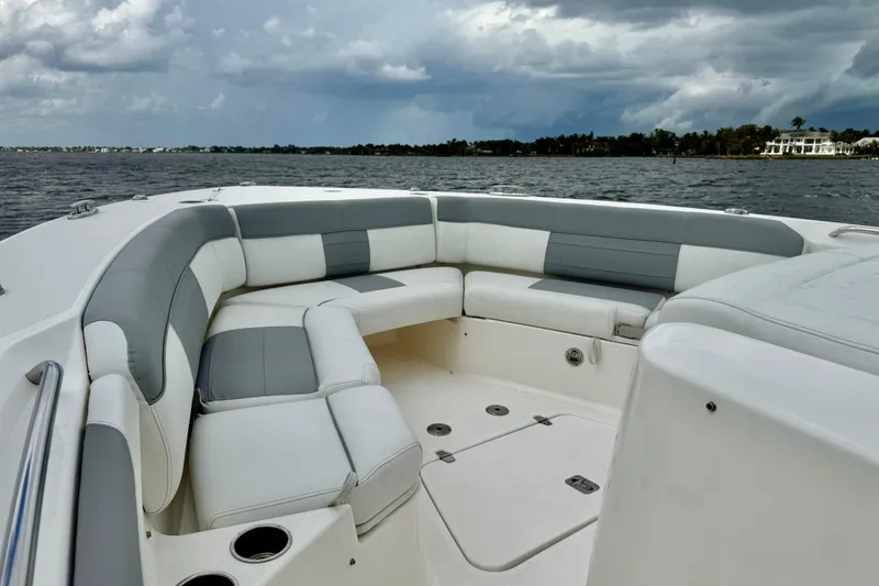 Slide: The Image of 2020 Pursuit S 408 Sport boat interior with cushioned seating on open water. - 14